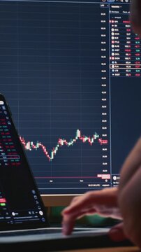 Close up: businessman hands working on laptop or computer keyboard for trading or stock market investing. Male investor sells and buys Bitcoin and crypto coins. Trader chart on terminal monitor.