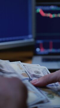 Close up: man trader or businessman counts salary usd banknotes at home with his hands. Male entrepreneur holds stack of dollar bills in palms, keeps money records for budget. Counting american paper