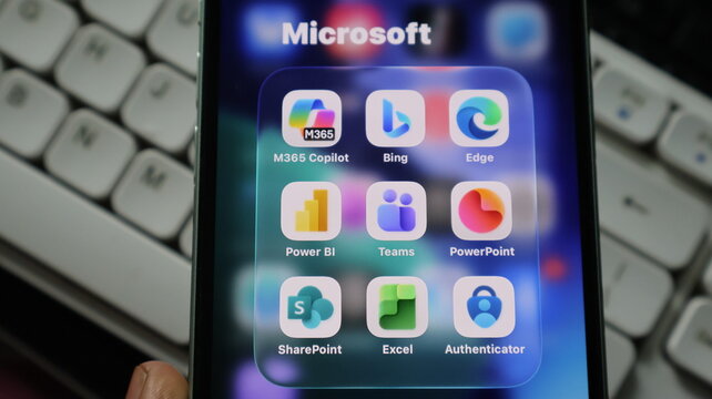 Closeup of a smartphone screen displaying a folder of microsoft applications including m365 copilot, bing, edge, teams, and excel