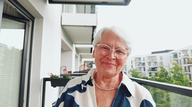 Senior Woman Smiling on Apartment Balcony 