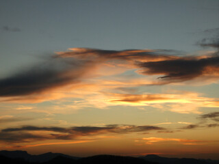 Fototapeta premium Atardecer con nubes en el cielo y montañas