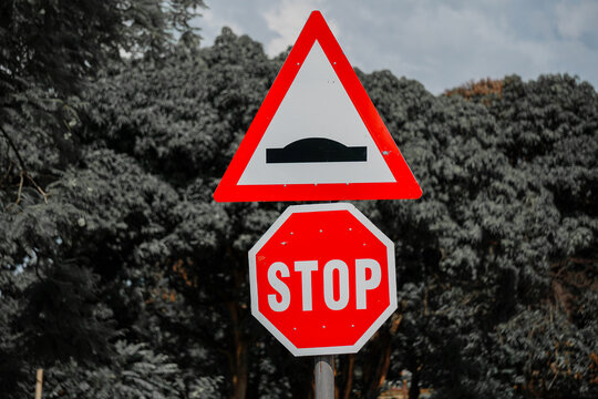 Traffic signs of a stop sign and a speed hump ahead sign.