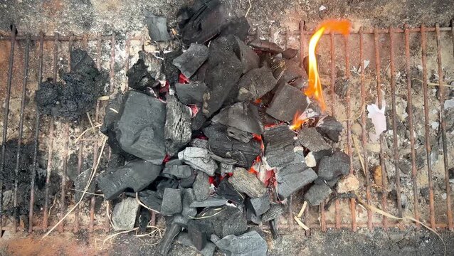 Top down view of burning lump charcoal on barbecue grill