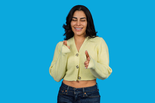 Cheerful young woman making finger guns gesture