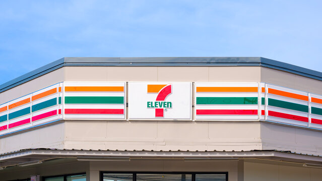 Samut Sakhon, Thailand - May 23, 2026 : 7-Eleven Convenience Store with Logo Signboard on Modern Geometric Polygonal Roof Design with Blue Sky Background