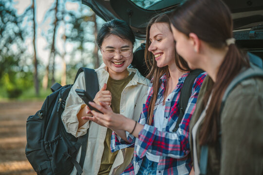 Friends planning road trip hiking adventure using smart phone navigation