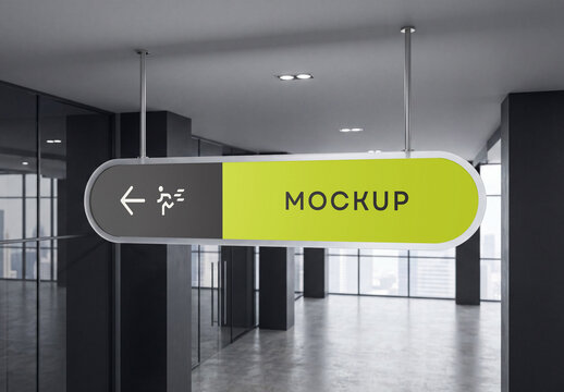 Horizontal oval ceiling hung navigation sign mockup suspended by metal rods in a modern dark office corridor with glass partitions and concrete floor