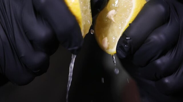 Chef exprimiendo lim&oacute;n fresco a mano para una receta de c&oacute;ctel. Un chef profesional exprime un lim&oacute;n fresco con las manos. T&eacute;cnica de c&iacute;tricos crudos, extracci&oacute;n artesanal de jugo natural.