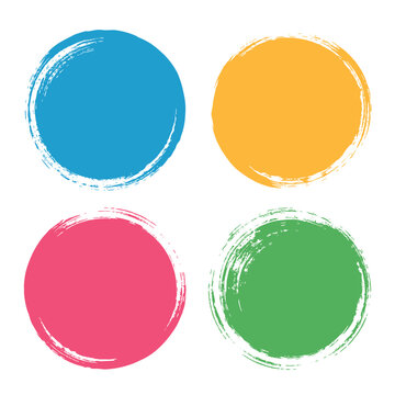 Four hand painted circular brush strokes in blue yellow pink and green colors arranged in a square grid formation on a white background with rough textured edges and visible bristle marks