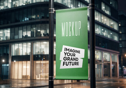 Vertical street lamp post banner mockup on twin poles at night with modern glass office building background
