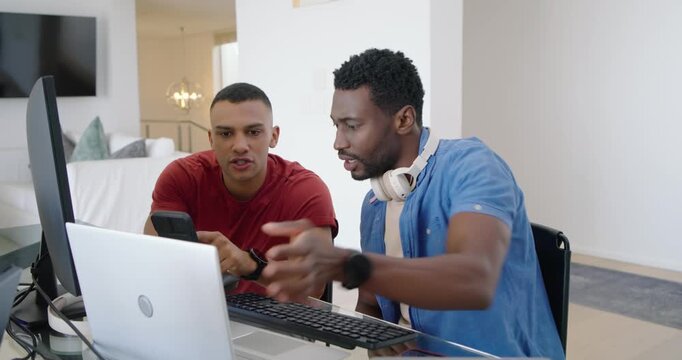 Diverse male friends in blue and red with red showing phone, comparing laptop while striped guiding