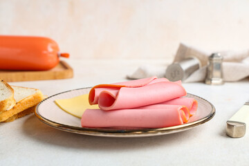 Plate with slices of tasty boiled sausage and cheese on grunge white background © Pixel-Shot