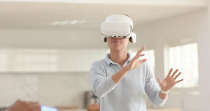Male friends seeing phone alert, Asian man gesturing in VR, removing headset, testing robot at home