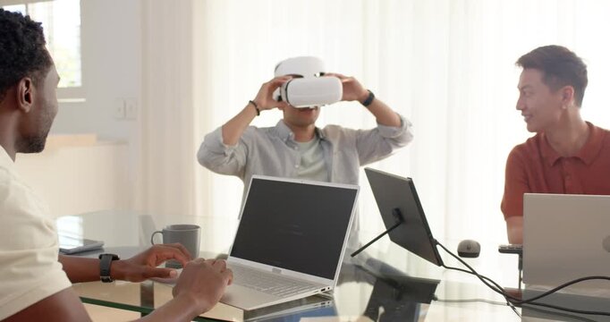 Diverse team watching center colleague lifting white VR headset and testing VR demo at glass table