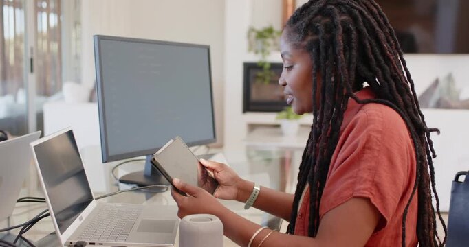 African American woman opening folded device, tapping screen in home office with laptop, copy space