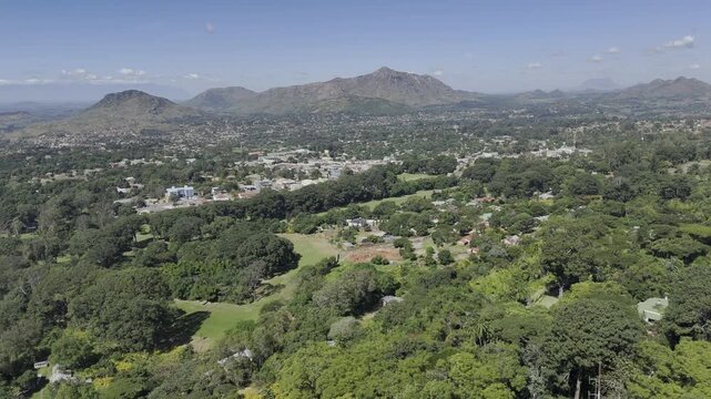 Drone facing east lowers to base of mountain on a sunny day in Zomba, Malawi