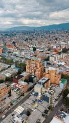 Obraz premium Aerial view of Bogotá cityscape under dramatic cloudy sky, Colombia