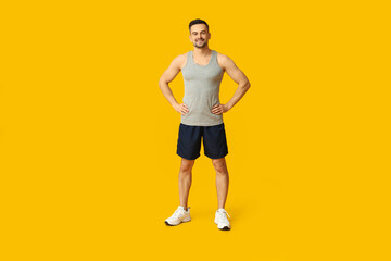 Fototapeta premium Handsome sporty young man on yellow background. Weight loss concept