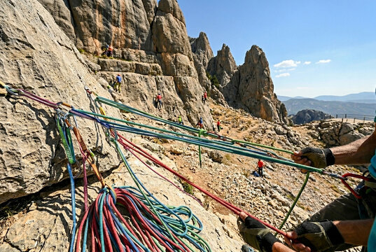 Close up of colorful climbing ropes with mountaineers on rocky cliffs