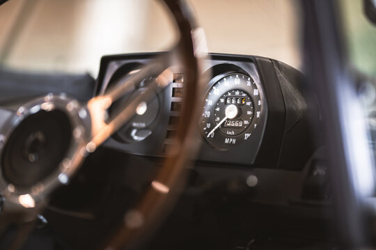 Vintage car dashboard with classic speedometer and steering wheel detail