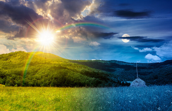 rural fields near mountain in summertime. day meet night. beautiful view of agricultural area. sun and moon in harmony over gorgeous mountain ridge with haystack on a grassy pasture. summer solstice