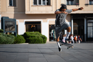 Skateboarder performing ollie trick in city square © Zoran Jesic
