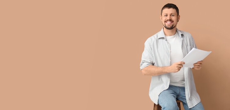 Male actor with movie script on beige background with space for text