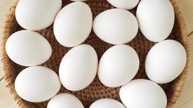 White chicken eggs rotating in a wicker basket