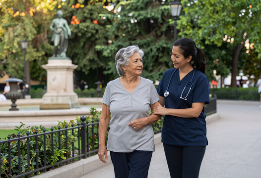 Filipino caregiver with elderly Spanish woman in Madrid park