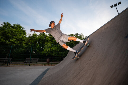 Skater riding ramp doing extreme skateboarding trick