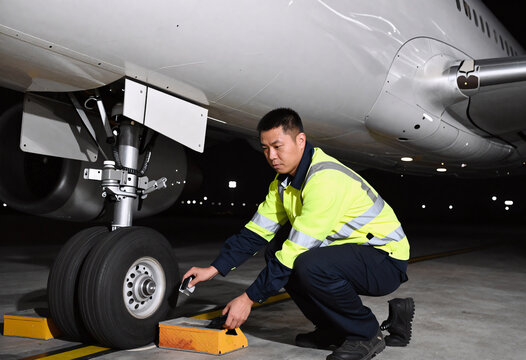Ramp Agent Removing Wheel Chocks Before Night Flight