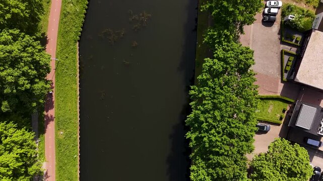 Drone flying over a city canal and bicycle path