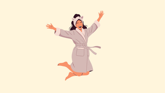 Happy woman wearing a comfortable bathrobe and a cat ear headband jumping with joy to celebrate a self care morning routine.