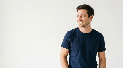 Obraz premium Smiling man in navy blue t-shirt looking to the side with copy space
