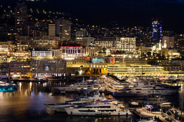 Fototapeta premium « Port illuminé de Monaco avec yachts et skyline nocturne » 