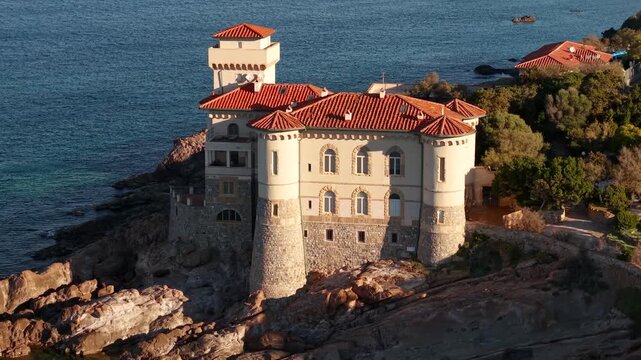 Castello del Boccale Tuscany Aerial 4K. Drone morning sun pull back close up castle on rocky shore seascape. Historic stone fortress overview in Livorno coast Italy. Beach castle travel destination