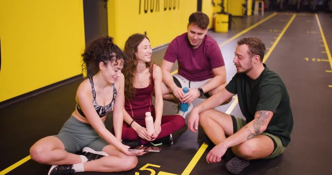 Friends at fitness center share workout tips and exercise ideas during their group session in the afternoon
