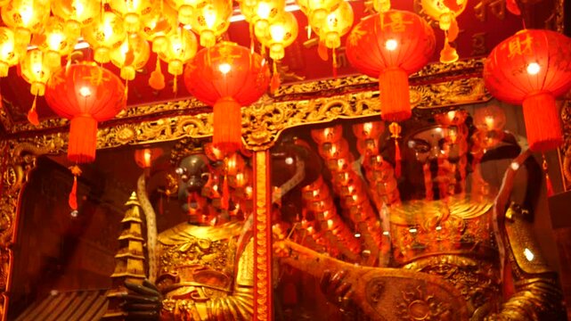 Chinese deities and red lanterns in temple during Lunar New Year