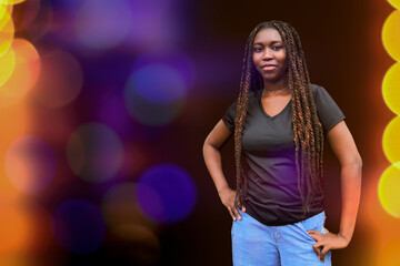 Fototapeta premium Young Black woman with long braids enjoying a fun night out under colorful neon club lights