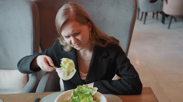 Educator reviews greens. Instructor inspects vegetable with doubt. Teacher carefully checks texture of salad. Dedicated instructor closely inspects freshness and feel of vegetable mixture carefully