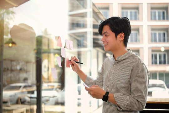 This man is writing notes on Post-it notes.