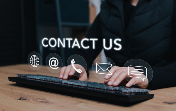 Contact us and customer support concept. person typing on keyboard with communication icons of phone, email, address, message and website address represent multi-channel business communication service