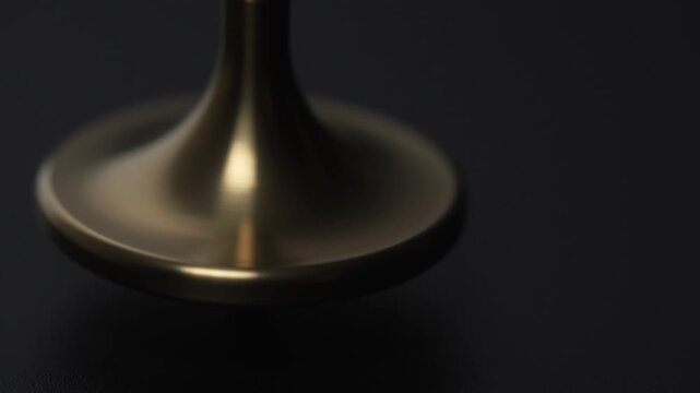 Seamless Loop of Stable Golden Spinning Top on Black Background
