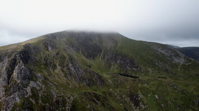 Cloud-Shrouded Mountain Ridge Above Glacial Cirque in Snowdonia