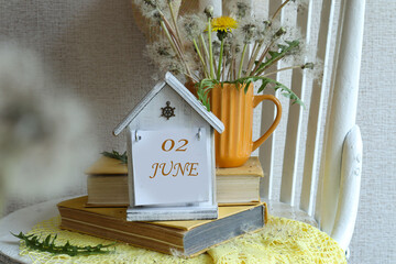 June 2 Calendar: A decorative calendar with the number 02 and the name of the month of June in English against a background of a bouquet of dandelions