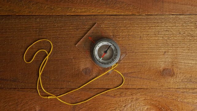A compass on a wooden table turning to north