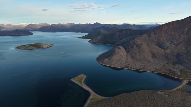 Aerial shot of coast near Provideniya, Penkigney Bay in Chukotka . Drone pan reveals bays, islands and mountain ridges in golden light. Arctic landscape for travel, adventure use