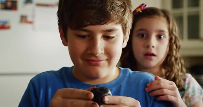 Older Brother Preparing Sweet Coal "Carb&oacute;n Dulce" for Sister on Three Kings' Day. Humorous, family, tradition concept.