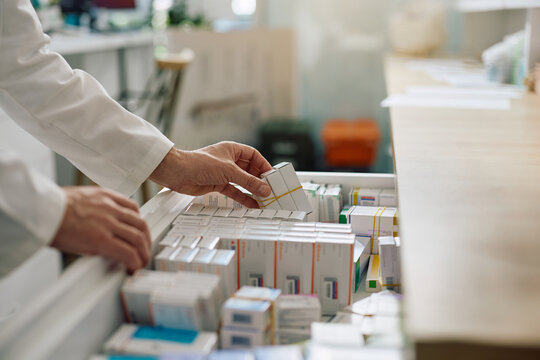 Close up of pharmacist taking medicine box from drawer.