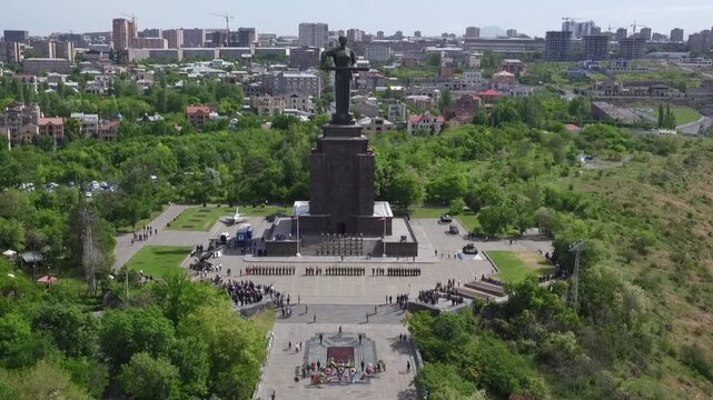 Aerial view of the Mother Armenia monument in Yerevan, featuring a military ceremony at the base of this giant statue on a bright sunny day in late spring.

